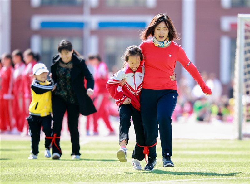 内蒙古呼和浩特市玉泉区恒昌店巷小学的学生和家长在参加"两人三足"